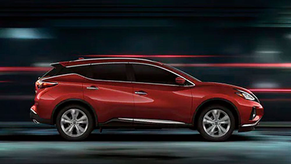 2023 Nissan Murano shown in profile driving down a street at night illustrating performance. | Performance Nissan of Pompano in Pompano Beach FL